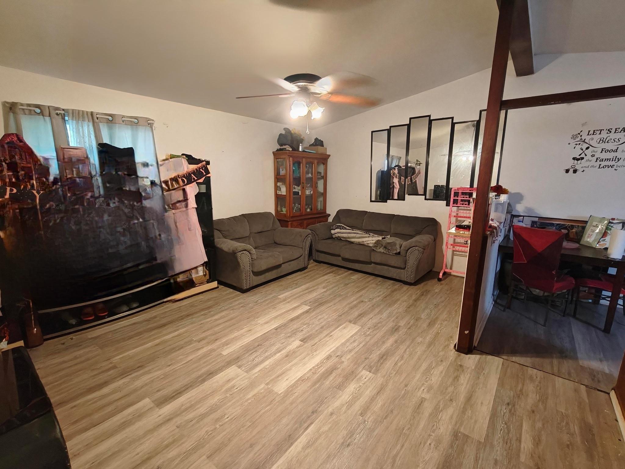 Living room with adjacent breakfast counter and kitchen area